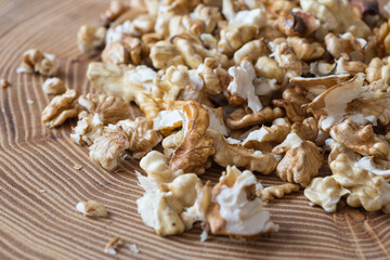 
A selective focus on fresh de-shelled walnuts (stone fruit) placed on acacia tree slice with visible growth rings