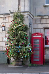 Fototapeta na wymiar Christmas tree and Red Phone box in the street.