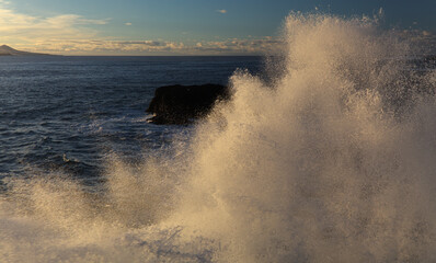 Powerful foamy ocean waves waves are breaking along Las Canteras and El Confital town beaches in Las Palmas de Gran Canaria