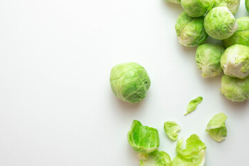 Fototapeta premium ripe Brussels sprouts lie on the table, next to its leaves