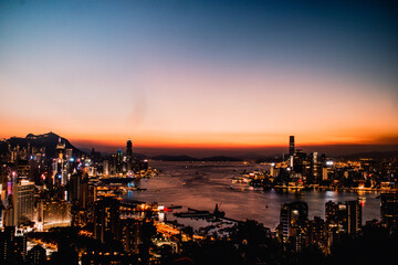 Obraz premium dos skyline de hong kong atardecer al fondo tonos azules y naranjas