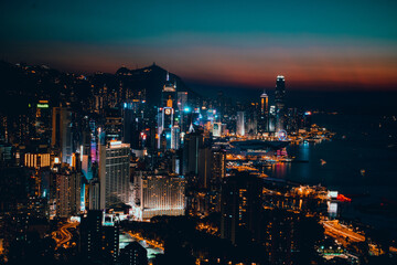 skyline hong kong al anochecer atardecer edificios altos luces y neones tonos azules y naranjas