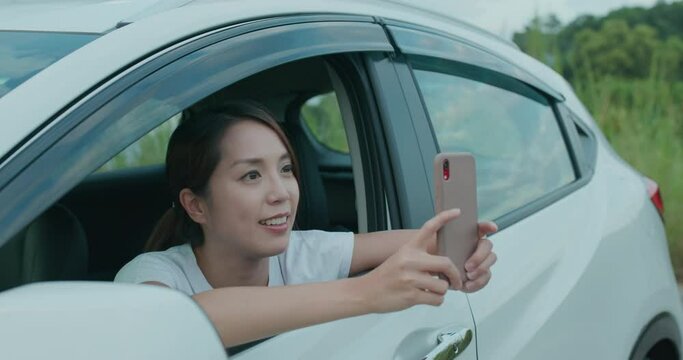 Woman use cellphone to take photo and sit inside car