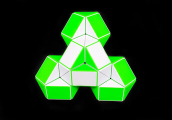 green and white geometric figure from puzzle toy isolated on black background
