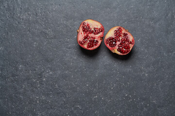 Top view of a colourful pomegranate isolated on dark grey stone background