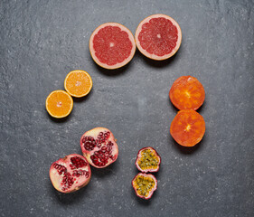 Pomegrade, orange, grapefruit, passion fruit and kaki on grey dark background