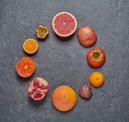 Orange, grapefruit, pomegrade, passion fruit and kaki on grey dark background
