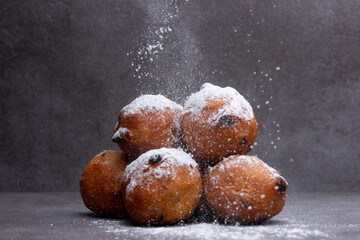 Sugar powder landing on homemade small Dutch oil balls delicacy traditionally eaten on New Year's...