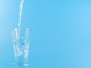 Glass with water aqua on blue background