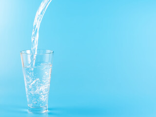 Glass with water aqua on blue background