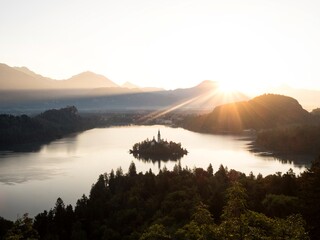 Panoramic sunrise view Lake Bled Island Blejsko jezero from Osojnica viewpoint hill Julian alps...