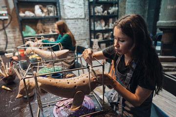 Fototapeta na wymiar Portrait of young woman enjoying favorite job in workshop.