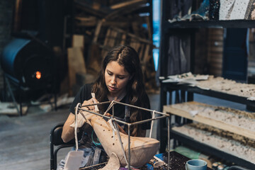 Portrait of young woman enjoying favorite job in workshop.