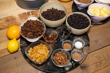 The ingredients for a fruity Christmas cake on a wooden kitchen work top