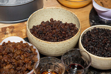 The ingredients for a fruity Christmas cake on a wooden kitchen work top
