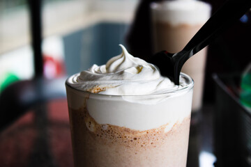 chocolate milkshake with whipped cream with spoon