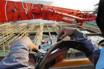 Construction worker control a pouring concrete pump on construction site. © Tanakorn