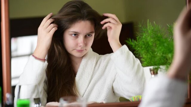 4k Young girl just woke up looking at herself in the mirror, cheking herself and her hair