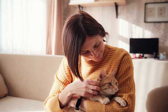 Young woman resting with pet in sofa at home.