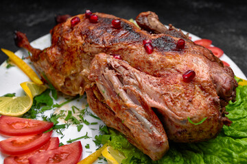 Roasted Christmas duck, on a white plate with vegetables, on a dark background