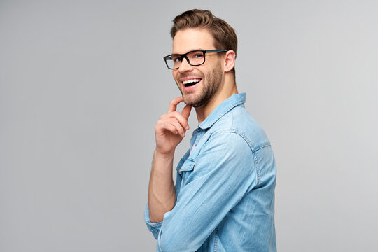 Portrait of young handsome caucasian man in jeans shirt over light background