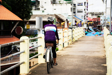 Life of thai people riding biking bicycle on small bridge cross Sakae Krang river go to Uthaithani city and local market in Uthai Thani Province of Thailand