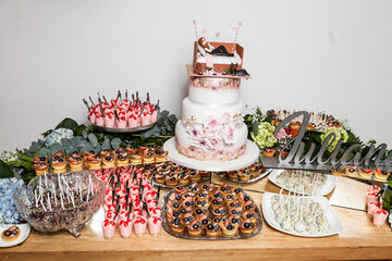 Table with sweets, desserts, and cake, decorated table for the reception; fifteen years old party.