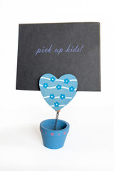 Wooden notes holder likes a pot with a swinging clip heart-shaped isolated on white. Commitments, family, tasks.  