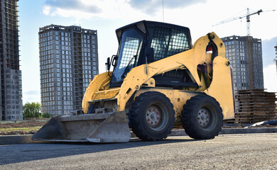 Skid-steer loader for loading and unloading works on city streets. Сompact construction equipment...