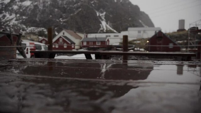 Gotas de lluvia cayendo sobre mesa de madera en pueblo nordico &Aring; 