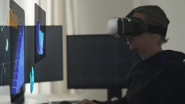 Close-up shot of a man with Augmented Reality VR glasses looking at futuristic stock market graphs and charts