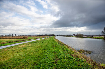 Dramatic skies over a Dutch polder landscape, with the canal surrounding Zuidplaspolder near Gouda with a higher water level than the adjacent Oostpolder