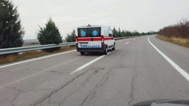 Corrona emergency patient is transported with ambulance van driving fast on highway road