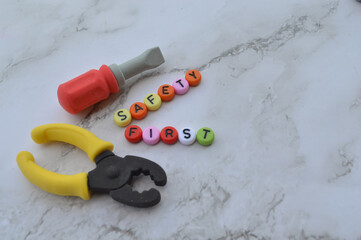 Selective focus with noise effect and blurred effect of toy tools and alphabet beads with tex SAFETY FIRST.