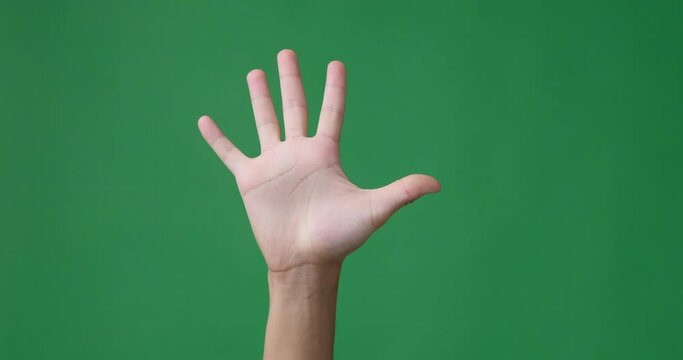 Male fingers counting from one to five over green background