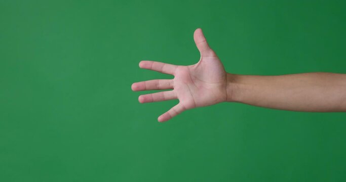 Male fingers counting from one to five over green background