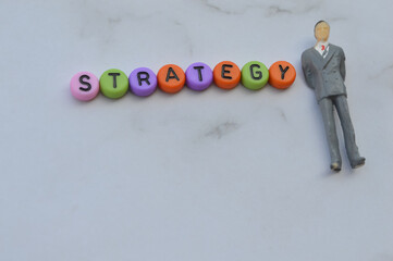 Selective focus with noise effect and blurred effect of miniature businessman and alphabet beads...
