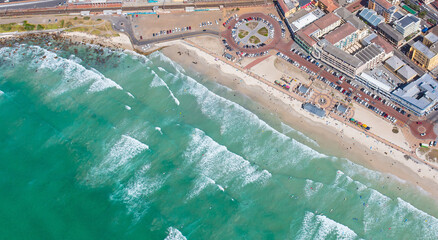 Cape Town, Western Cape, South Africa - 12.22.2020: Aerial photo of Muizenberg Beachfront and surfers