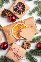 Christmas holidays zero waste paper gifts wrapping with tag, baubles, dried fruit and fir branches