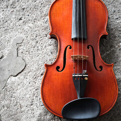 Front side of violin put at the right side of grunge surface cement ground floor,