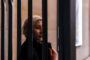 Fototapeta na wymiar Woman posing behind bars
