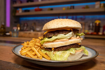 A classic home made burger and chips on a wooden table