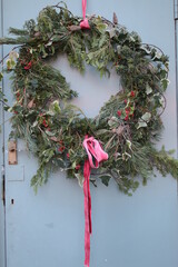 Close up of frost on Christmas festive wreath garland hung on door with white frozen coat of ice on...