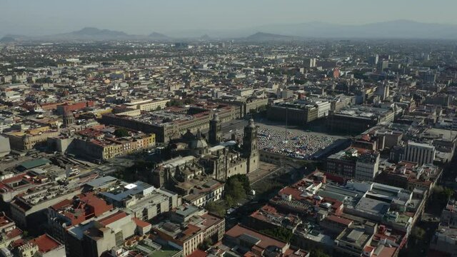 Drone Flies Away from Mexico City Zocalo on Hazy Day. Pan Up