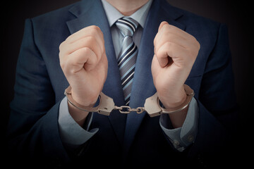 Businessman arrested, man in suit with handcuffs