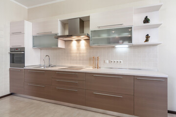 Modern kitchen interior with beige and light brown faсade pannels.