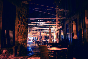 Moody scene of empty cafe with decorated street at night in old Spanish mountain village Fornalutx, Mallorca, Spain