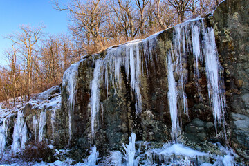Blue Ridge Parkway – Huge icicles hanging from cliff wall with trees above