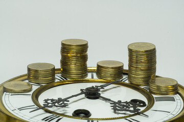 stack of coins on vintage clock