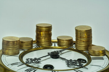 stack of coins on vintage clock